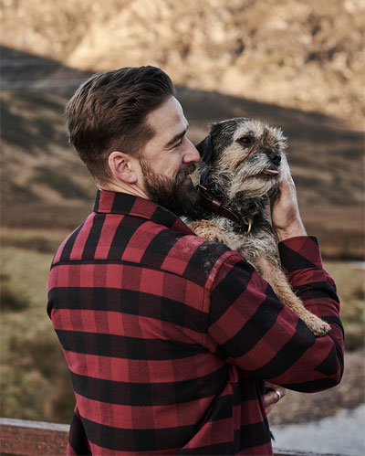 Man wearing Hoggs of Fife Tentsmuir country shirt whilst holding a dog